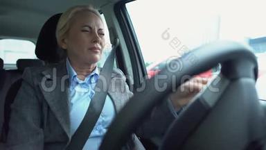 老年女商人感到偏头痛，坐在司机座位上，享受医疗保健